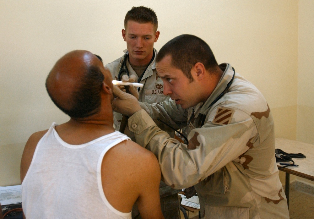 Sergeant David Edwards examines a Iraqi Police Cadet