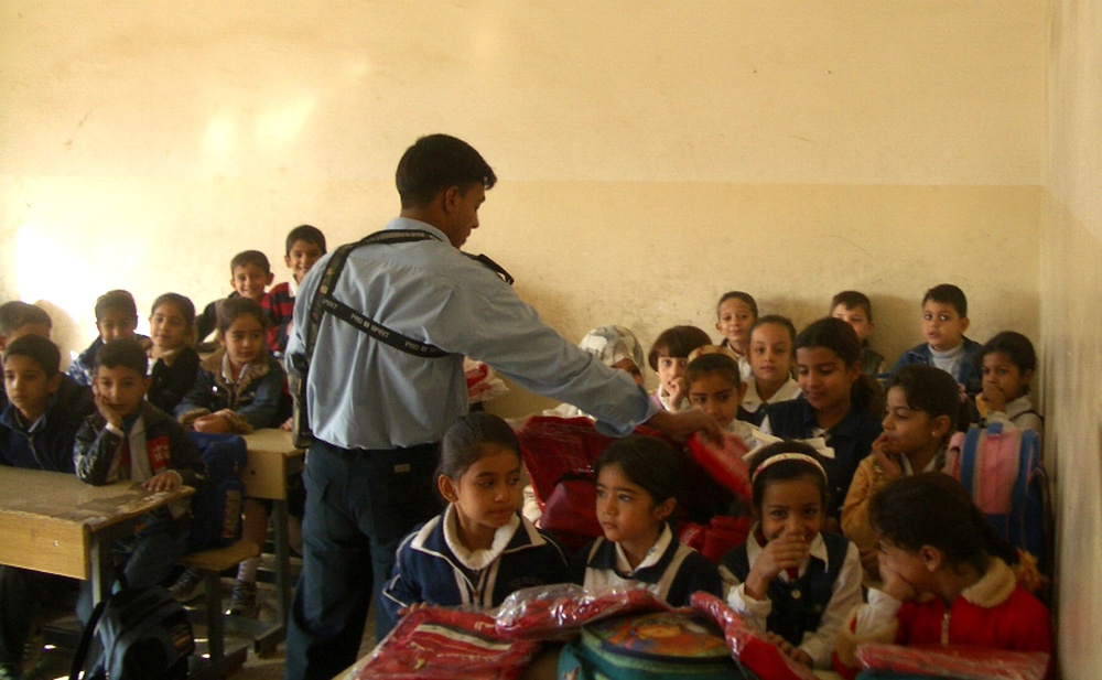 N Iraqi Police Officer Hands Out School Bags