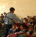 N Iraqi Police Officer Hands Out School Bags