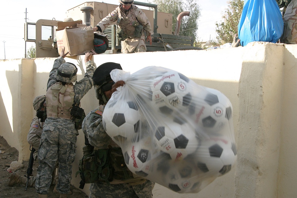 Command Sgt. Maj. Lorria P. Anderson helps unload a five-ton truck of toys
