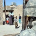 Local residents of Tal Afar watch as a patrol passes by