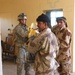 Iraqi army soldiers and U.S. paratroopers unload a truck load of blankets