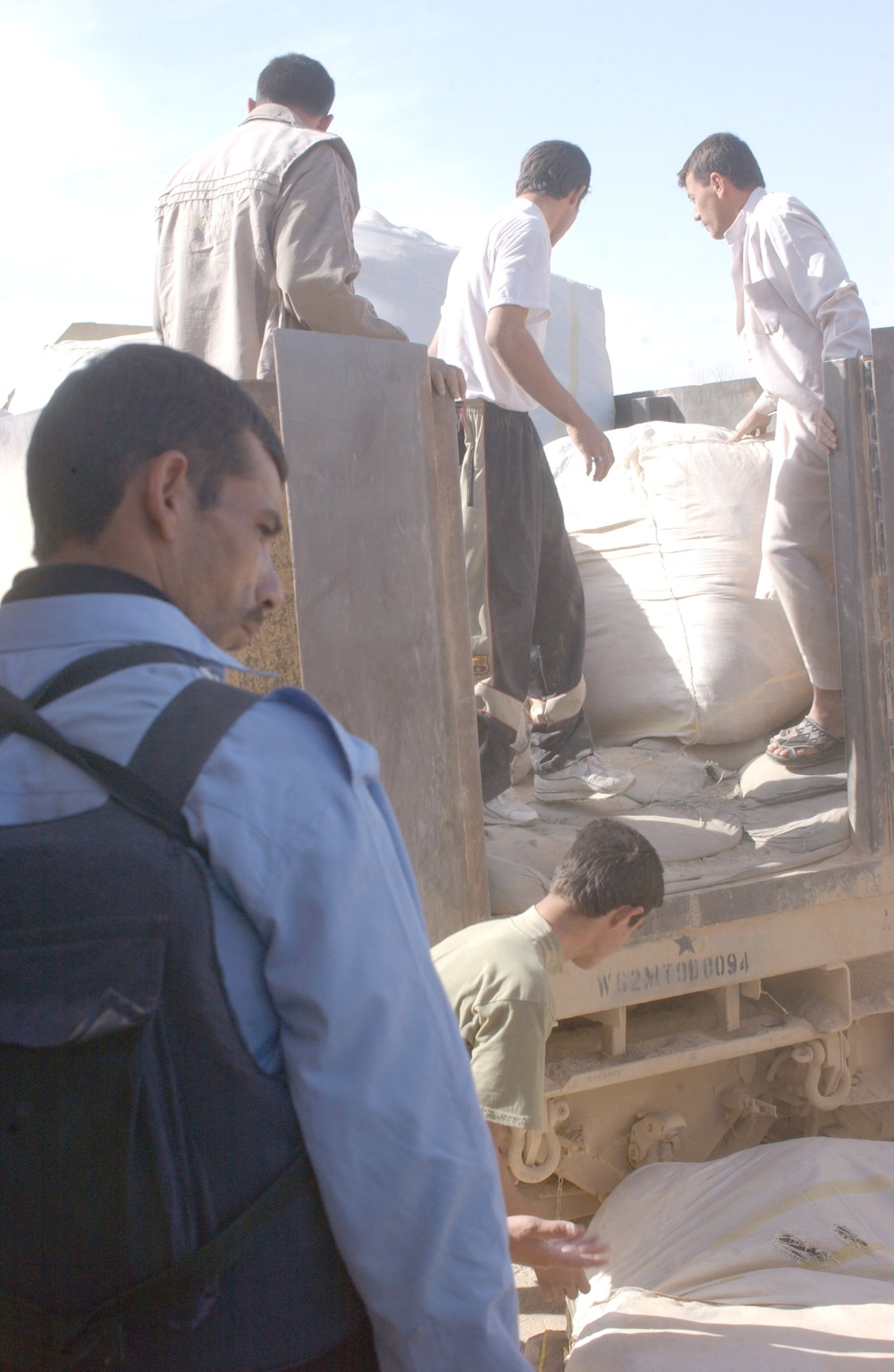 Local workers unload bundles of blankets from a truck