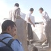 Local workers unload bundles of blankets from a truck