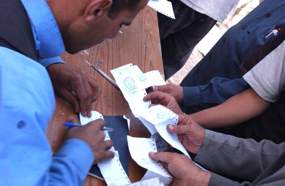 Iraqi Residents Hold Out Ration Cards