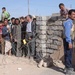 An Iraqi police officer stands guard at a gate