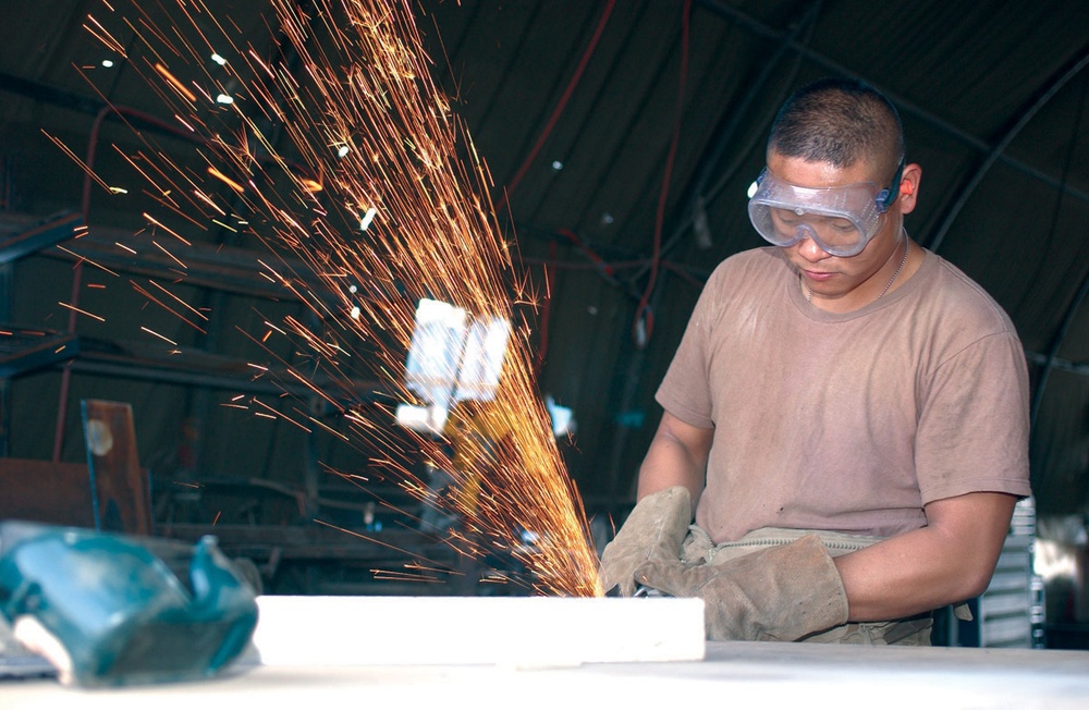 Pvt. Dan L. Trinidad Cuts a Sheet of Metal