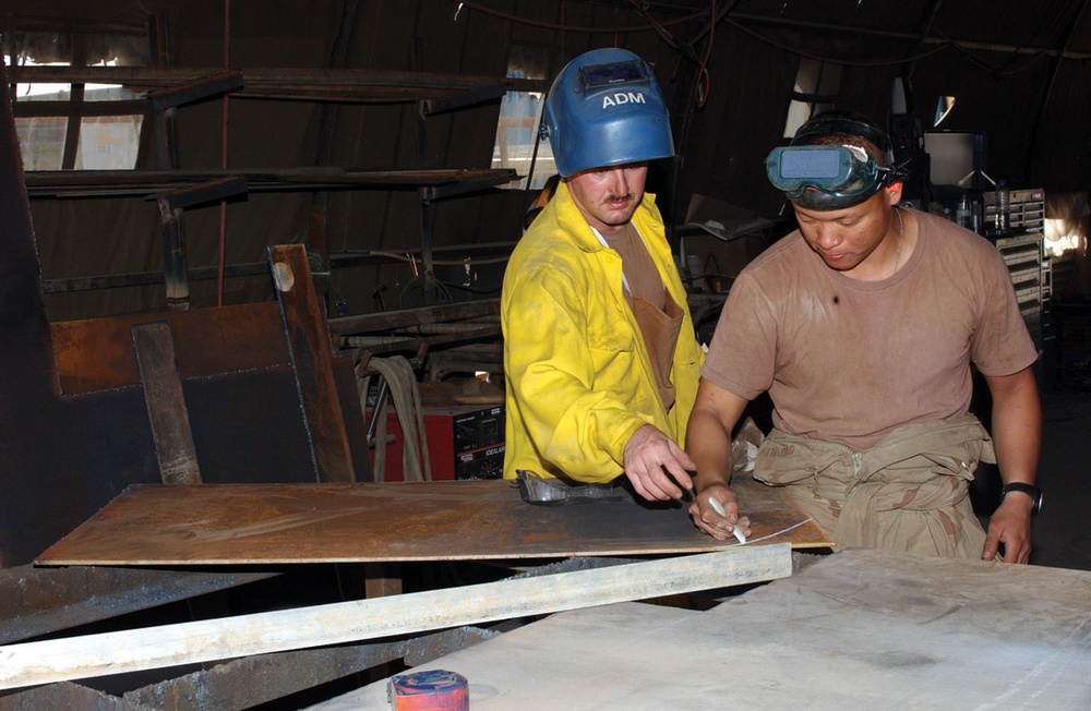 Sgt. Mendenhall and Pvt. Trinidad mark heavy metal sheets for cutting