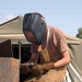 Spc. Eric W. Smith welds armor surrounding the gunner's turret of an