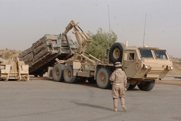 2nd Lt. Blair observes as Soldiers unload Hesco barriers