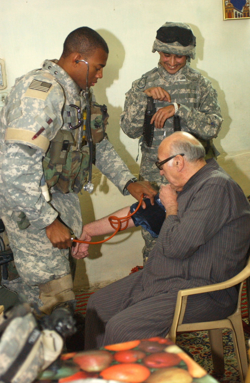 BAGHDAD, IRAQ -- Sgt. Clydell White, of Houston, TX, a medic with the 1-10 Mountain Division's 2nd Battalion, 22nd Infantry Regiment, checks the blood pressure of an elderly Iraqi citizen while an interpreter looks on, during a patrol the battalion condu