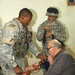 BAGHDAD, IRAQ -- Sgt. Clydell White, of Houston, TX, a medic with the 1-10 Mountain Division's 2nd Battalion, 22nd Infantry Regiment, checks the blood pressure of an elderly Iraqi citizen while an interpreter looks on, during a patrol the battalion condu