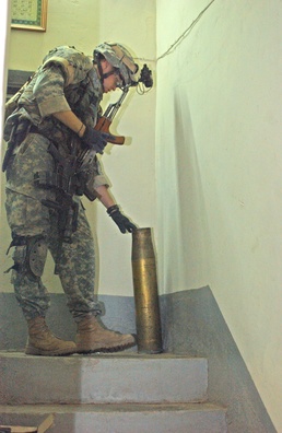 Sgt. Jason Millay Inspects an Artillery Shell Casing