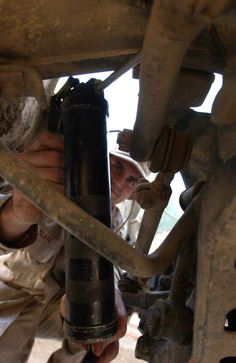 Soldier greases humvee