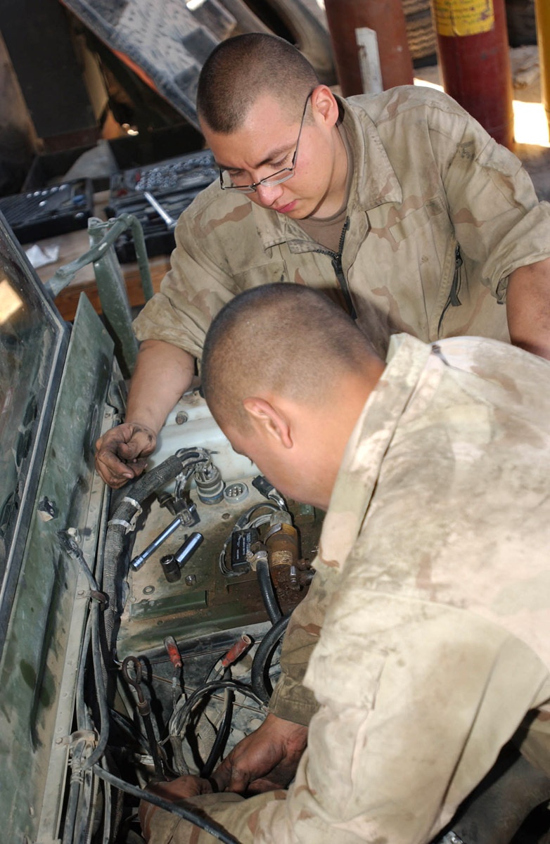 Soldiers repair humvee