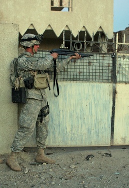 Private 1st Class Green prepares to blast  a lock off the gate of an abando