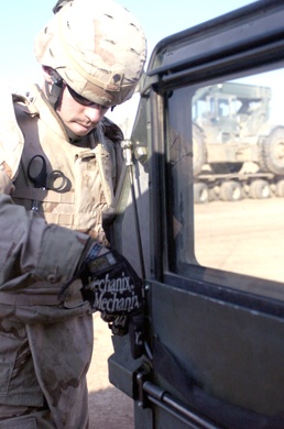 Spc. Robert Birkla fixes a door on a humvee