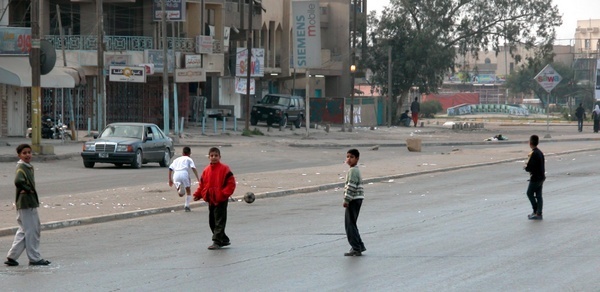 Children play soccer in the deserted streets of Baghdad