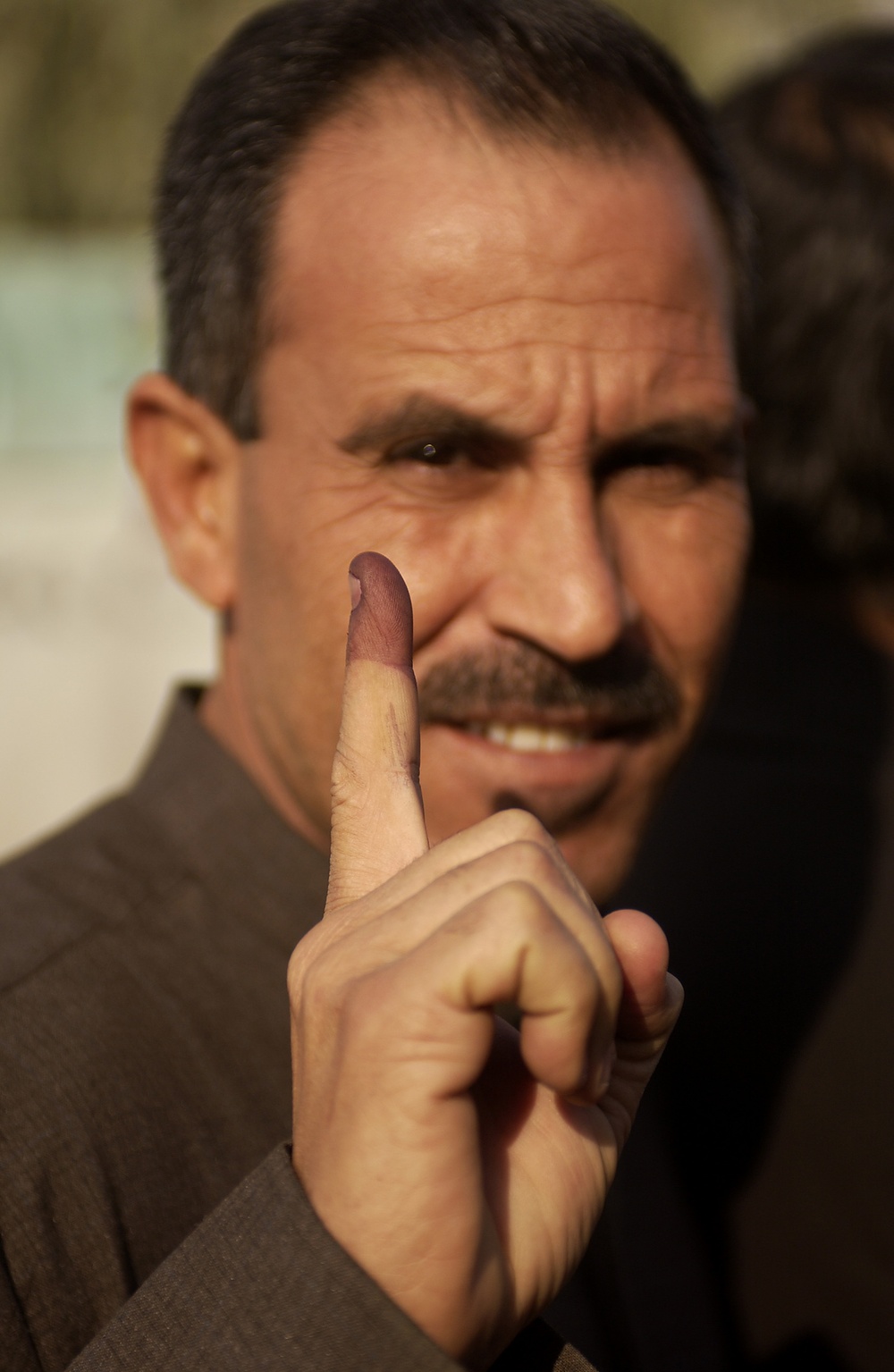 A local Iraqi man shows his inked finger after voting