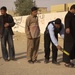 Iraqi police check local Iraqi men waiting to enter a polling station