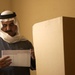 An Iraqi man marks yes or no on his ballot