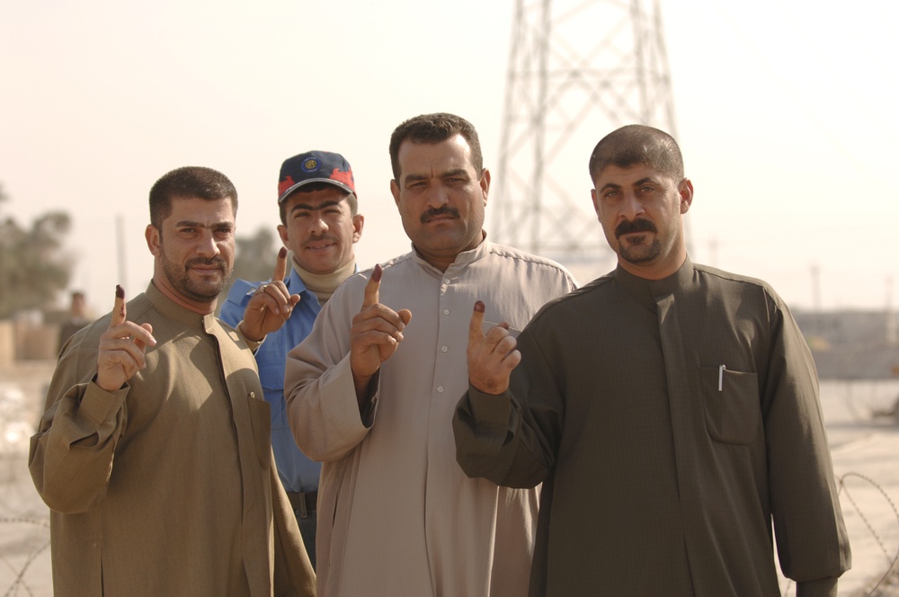 Iraqi citizens show their inked index fingers