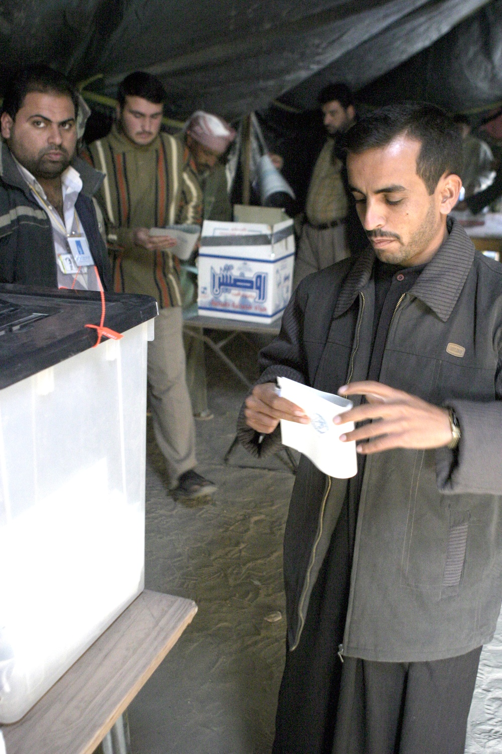 An Iraqi man folds is ballot