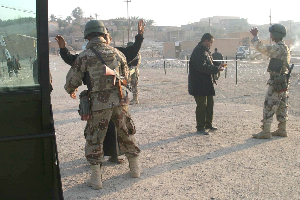 Iraqi voters are searched by Soldiers