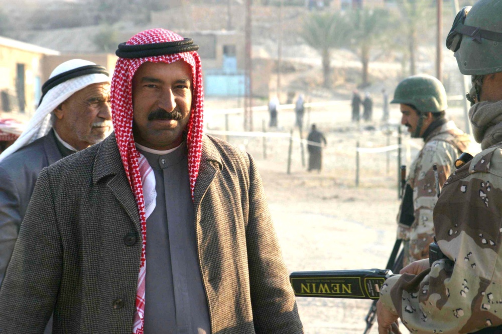 An Iraqi man smiles as he walks into the polling center