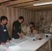 Two Soldiers get their ballots from poll workers