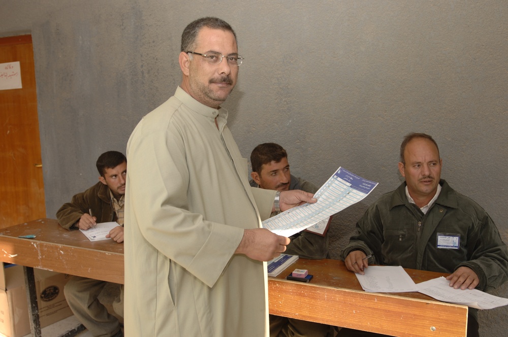 An Iraq citizen takes a ballot