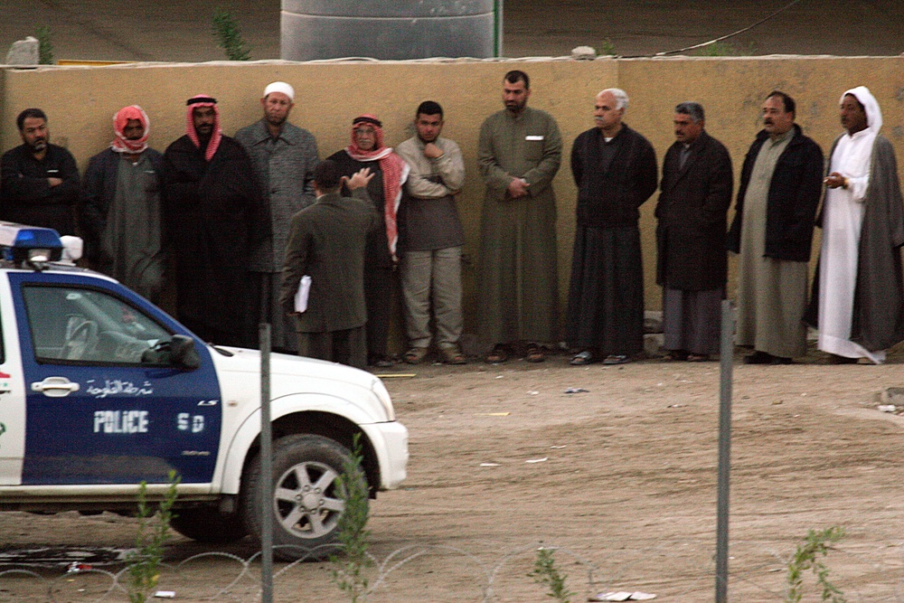 Citizens of Fallujah stand at a polling site