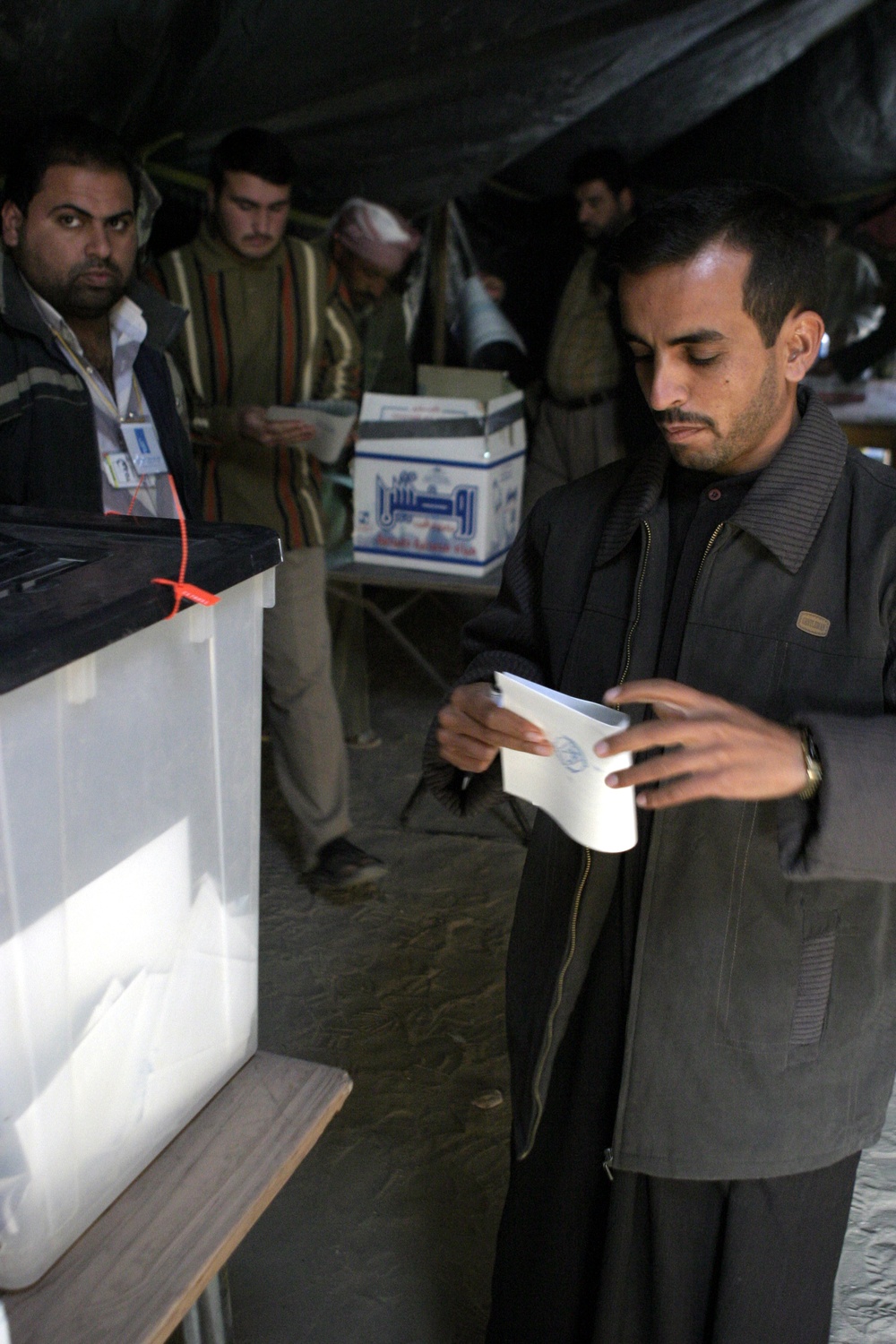 An Iraqi man folds his ballot