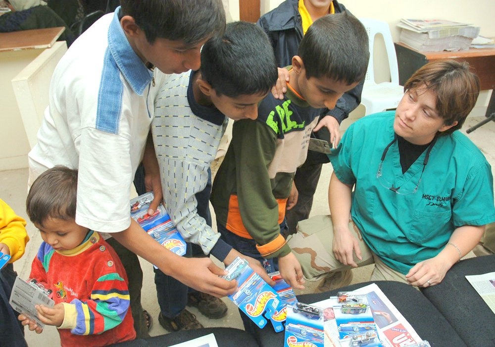 Master Sgt. Elmore hands out toy cars to young Iraqi boys