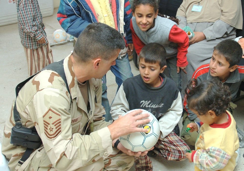 Master Sgt. Bonnar discusses soccer with a young Iraqi boy
