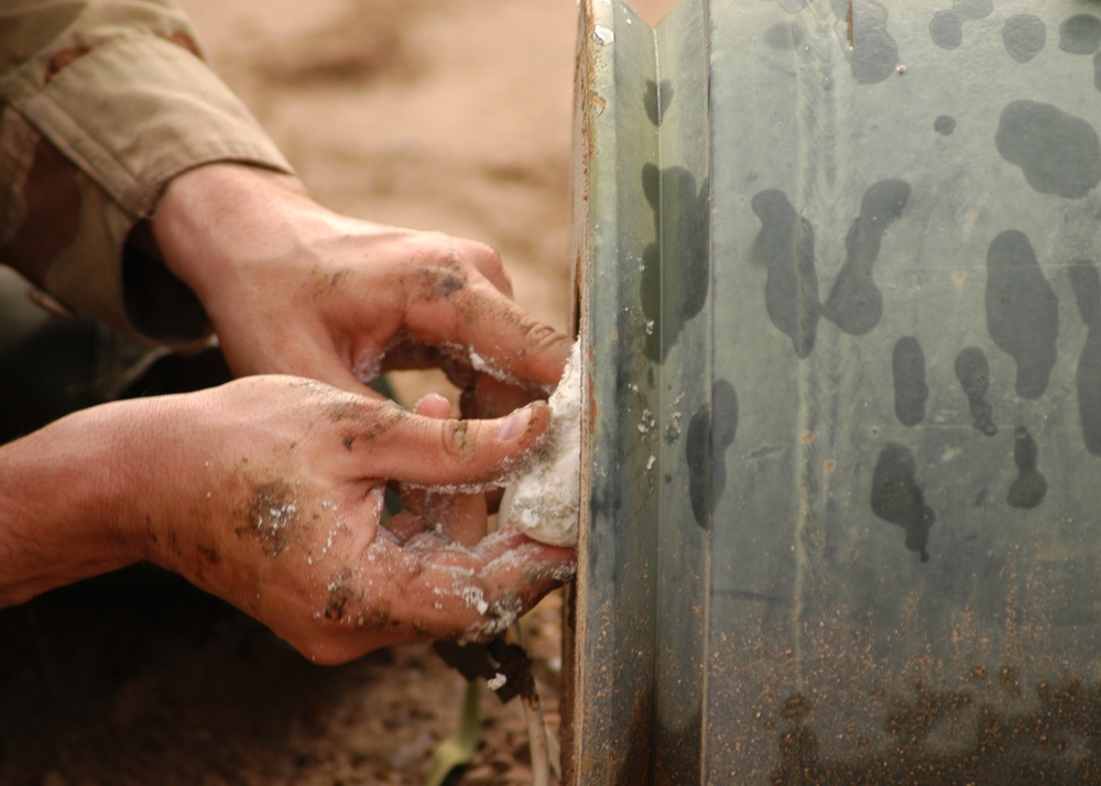 Sgt. 1st Class Morrison packs a one thousand pound bomb with plastic explos