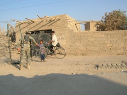 A Soldier greets two boys near a checkpoint in Ramadi