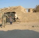 A Soldier greets two boys near a checkpoint in Ramadi