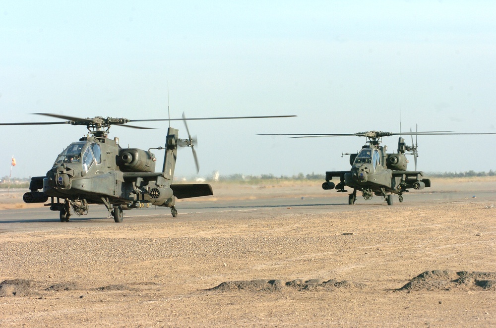 Two AH-64 Apaches taxi down the runway