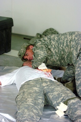 Spc. Pearl checks the breathing of a simulated casualty