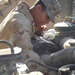Pfc. Cedano checks the oil on a Humvee