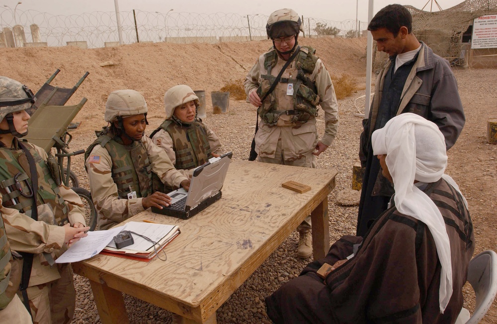 Soldiers at LSA Anaconda help Iraqis file claims.