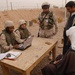 Soldiers at LSA Anaconda help Iraqis file claims.