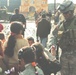 Sgt. Warren shakes hands and jokes with some Iraqi children