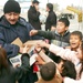 An Iraqi police officer hands out candy and toys to children