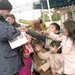 An Iraqi police officer hands out candy and toys to children