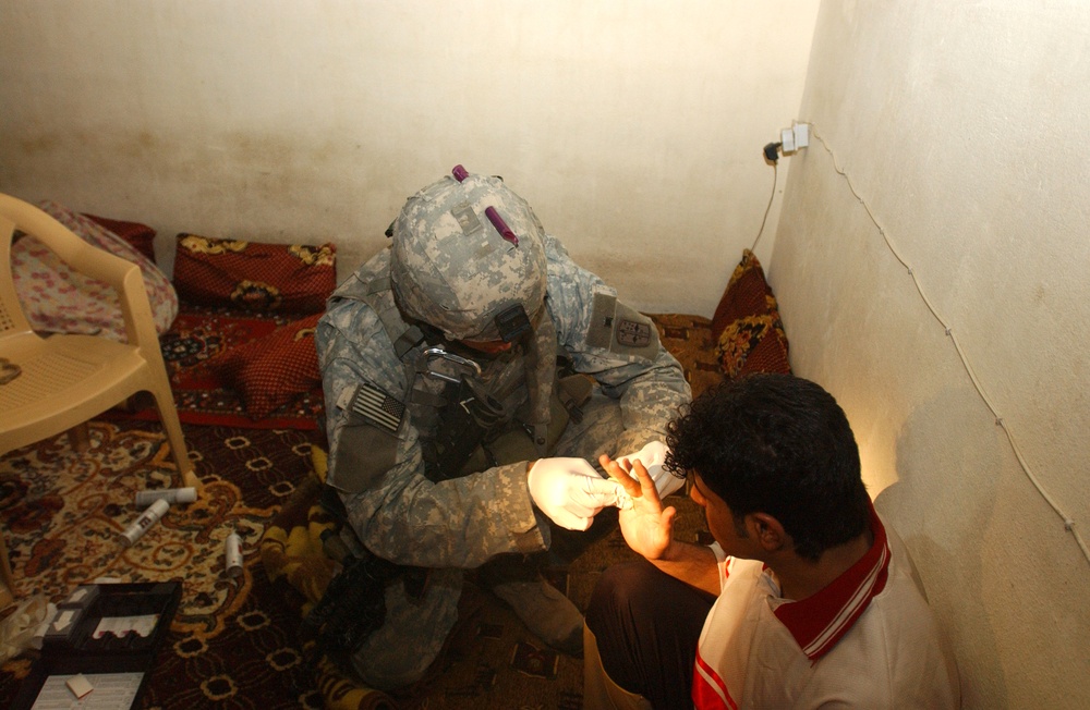 A Soldier checks a suspected terrorist for bomb making materials