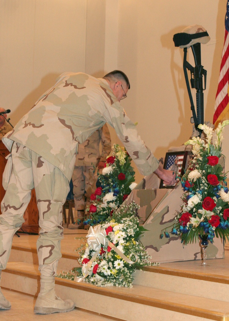 A troop places a coin on the memorial of Sgt. McMullen