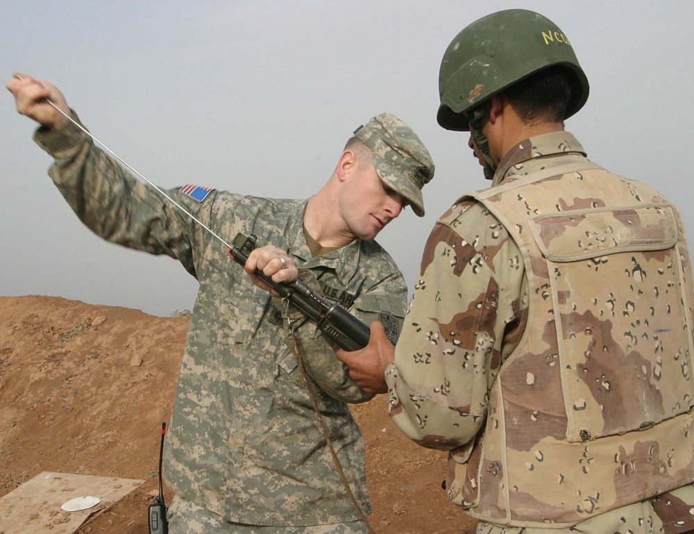 Staff Sgt. Cates checks an Iraqi soldier's weapon