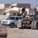 An Iraqi Soldier provides security for others as they procure concrete barr